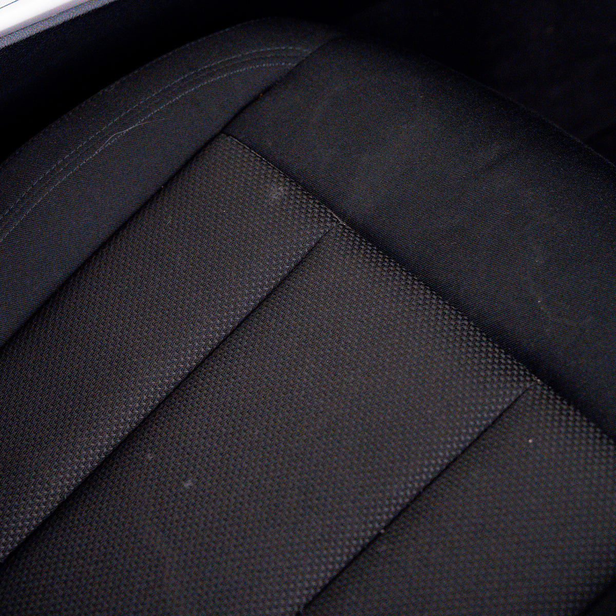 Close-up of a black car seat with visible texture