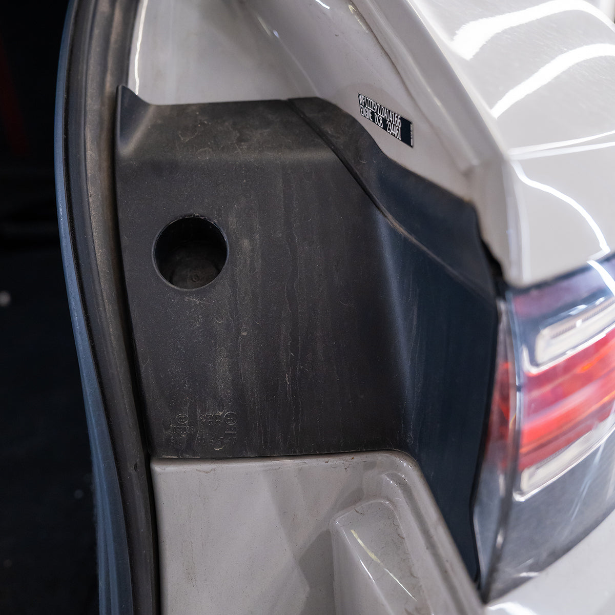 Close-up of a car&#39;s rear bumper with a visible brand logo.